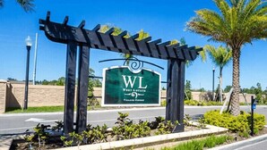 A sign for West Lucida Village Resort with a pergola structure in front. - Last Minute Disney Getaway! Townhouse with Private Pool. Book Now! #125775 (Orlando)