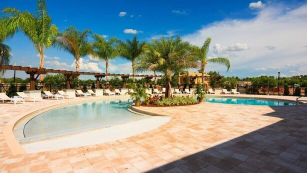 A pool area with lounge chairs and palm trees. - Last Minute Disney Getaway! Townhouse with Private Pool. Book Now! #125775 (Orlando)