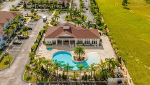 A residential area with a large house featuring a swimming pool, surrounded by palm trees and a well-maintained lawn. - Last Minute Disney Getaway! Townhouse with Private Pool. Book Now! #125775 (Orlando)