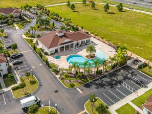 A residential area with a swimming pool, a covered patio, and a parking lot.