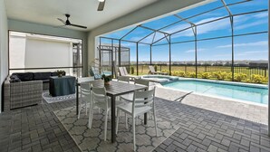 A covered patio with a pool, seating area, and a ceiling fan. - Last Minute Disney! Private Pool, Hot Tub, Game Room & Themed Bedrooms. Book Now! #128641 (Orlando)