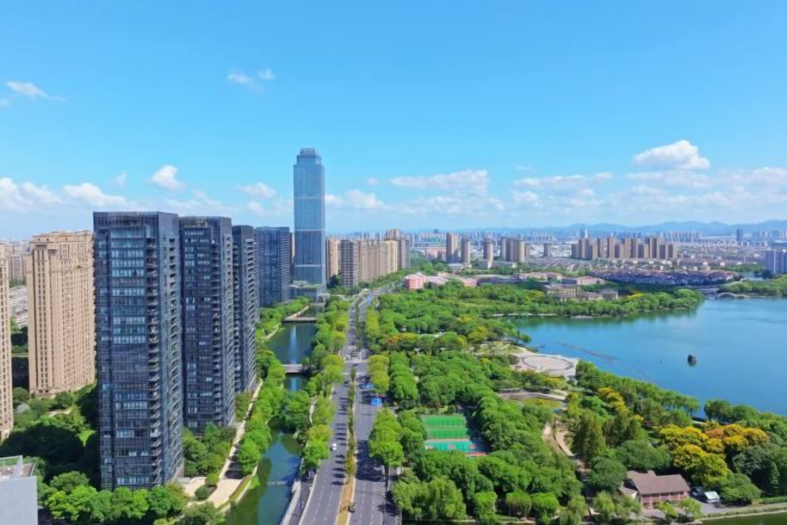 A high-rise building complex with a river and park area in the foreground.