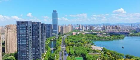 A high-rise building complex with a river and park area in the foreground.