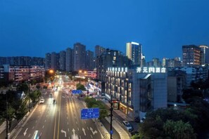 A cityscape at dusk with a prominent building labeled "Zhongyuan Hotel".