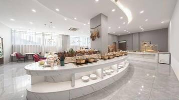 Un lobby moderno de hotel con mostrador de recepción de mármol, zona de estar y un amplio ventanal que proporciona luz natural.