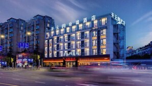 Un hôtel moderne, doté de nombreux étages, de grandes fenêtres et d’une entrée imposante.