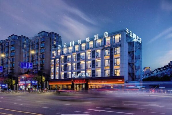 A modern hotel with multiple floors, large windows, and a prominent entrance.