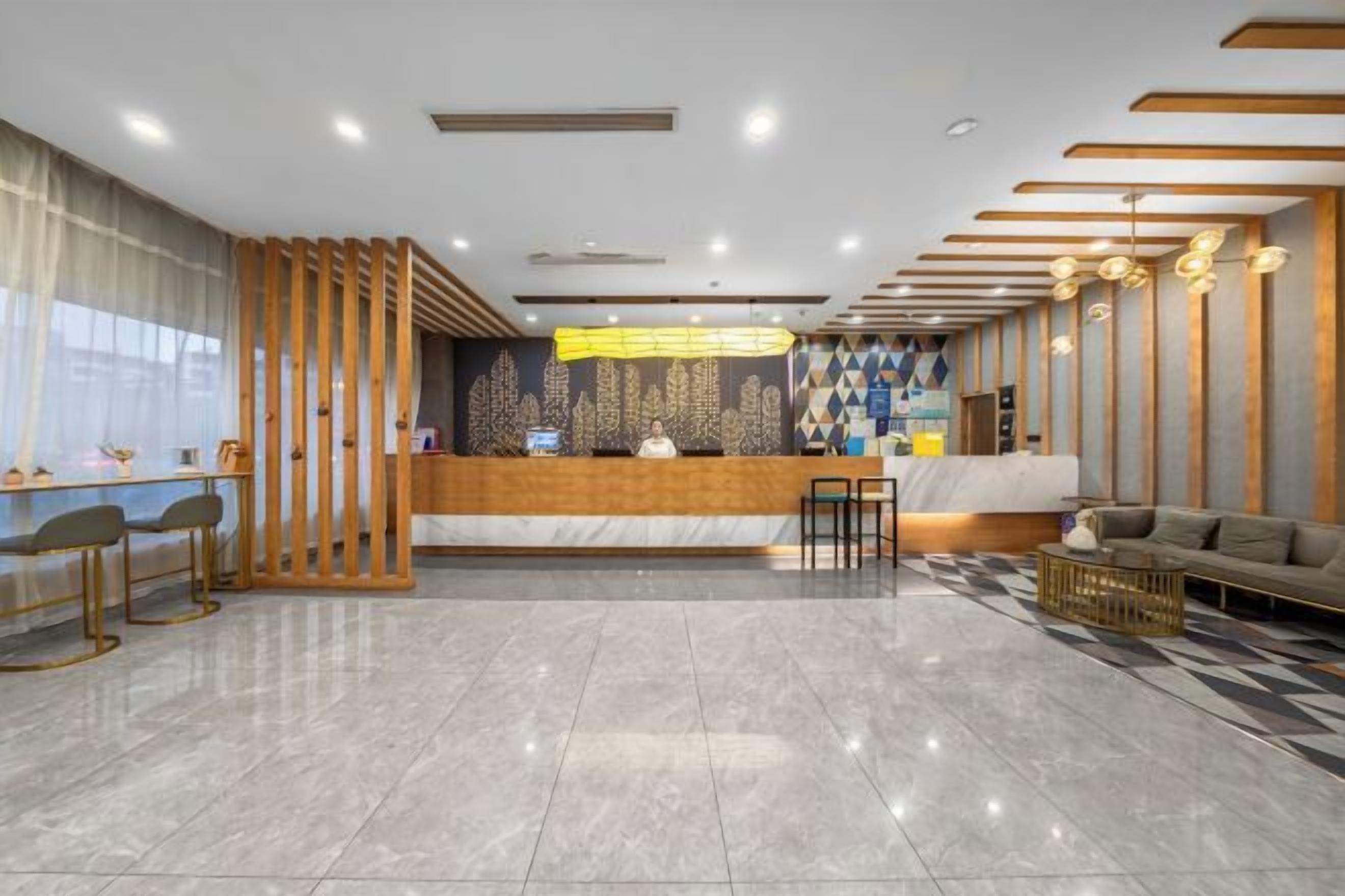 Um lobby de hotel moderno com balcão de recepção, área de estar e painéis decorativos na parede.
