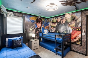 A bedroom with a bunk bed, a mural of animated characters, and a ceiling fan.