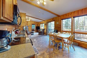Enjoy meals together at the large dining table, surrounded by comfortable chairs, in this cabin-style room with a fully equipped kitchen.