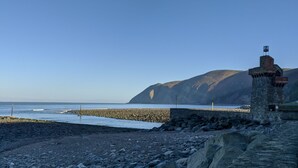 Ein felsiger Strand mit einer Steinstruktur und einer Flagge darauf.
