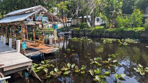 Une jetée avec un banc en bois, un petit bateau et un panneau indiquant « Point de départ, à 0 mille de Key West ».