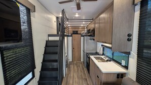 A compact kitchen with a central island, wooden cabinets, and a built-in stove.