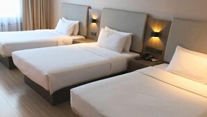 Une chambre d’hôtel avec deux lits simples, chacun doté d’une tête de lit et de tables de chevet.