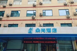 A hotel with a blue and white facade, multiple air conditioning units, and a digital display board. - Hanting Hotel (Yanggu Gushan Road) (Yanggu)