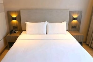 A hotel room with a large bed, two bedside tables, and wall-mounted lamps. - Hanting Hotel (Yanggu Gushan Road) (Yanggu)