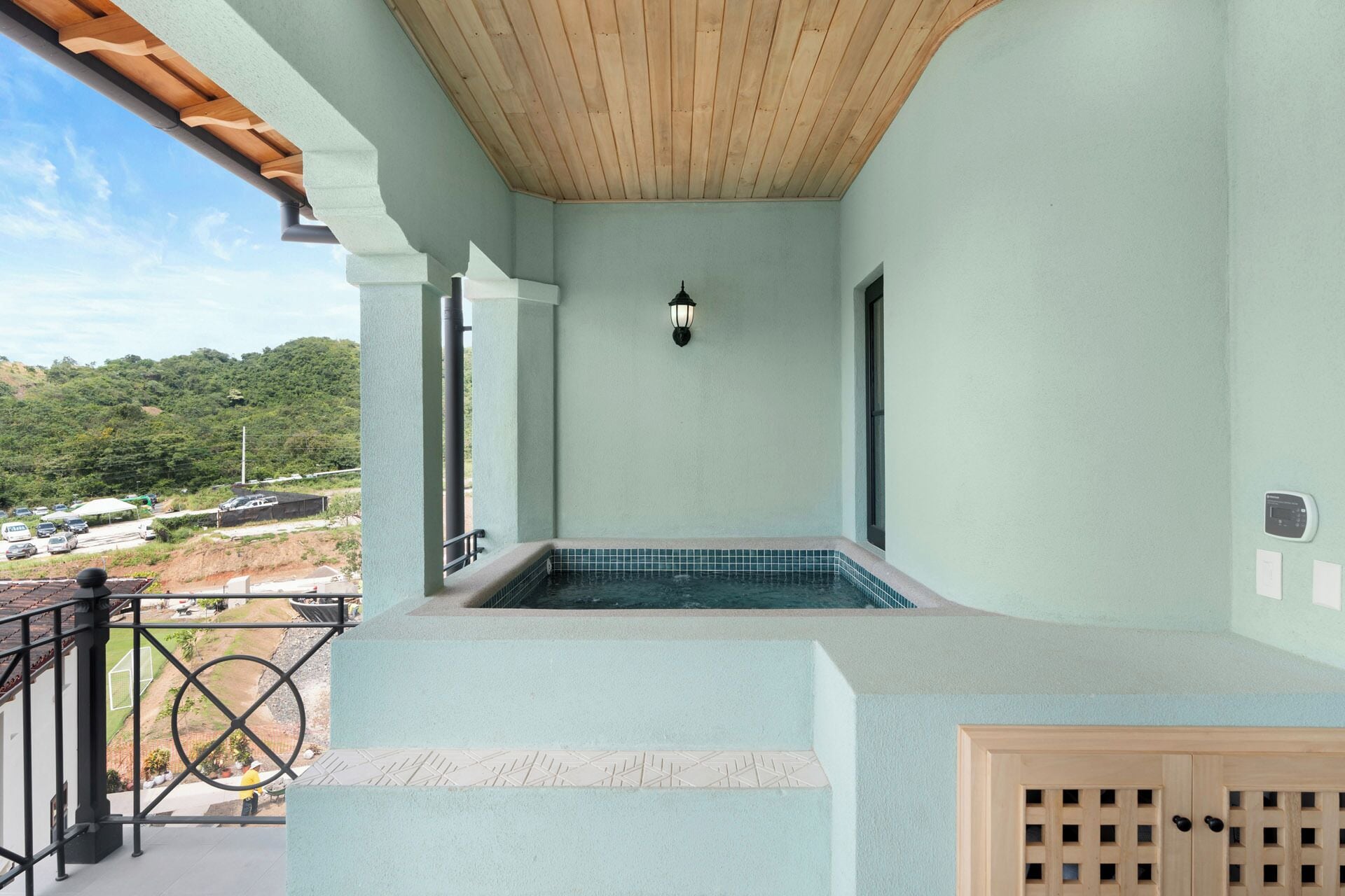 Ein Balkon mit Blick auf einen Swimmingpool, ein Fahrrad und einer Holzbeschichtung.