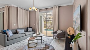 Un salon moderne avec un canapé gris, une table basse ronde et un fauteuil gris.