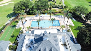 An aerial view of a resort with a swimming pool, palm trees, and a golf course. - Reunion resort (7 guests) near Disney (Kissimmee)