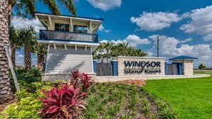Une enseigne pour le complexe hôtelier Windsor Island Resort, avec un bâtiment moderne et un jardin aménagé.