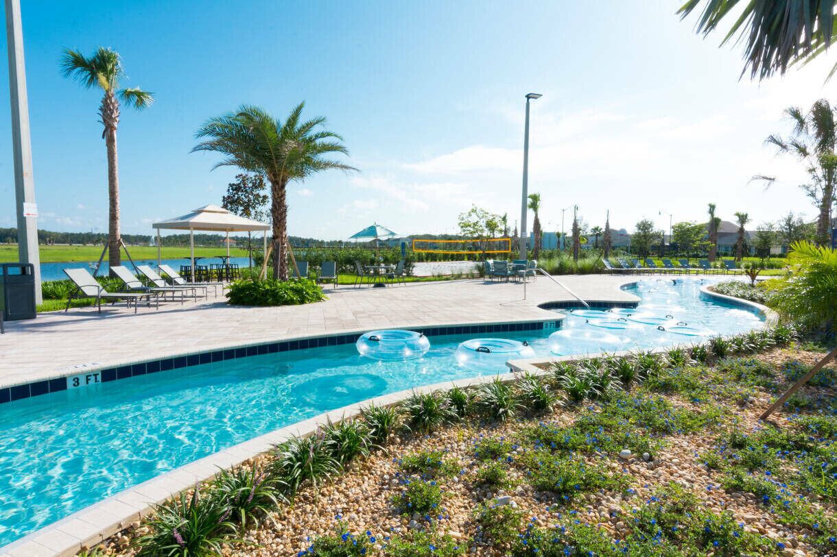 A swimming pool with lounge chairs and a covered seating area.