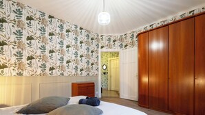 Un dormitorio con una cama grande, un armario de madera y una mesita de noche.
