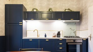 Una cocina moderna con armarios oscuros, encimera blanca y horno integrado.