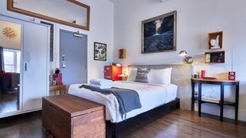 Una camera da letto con un letto, un comodino e un settimino in legno.