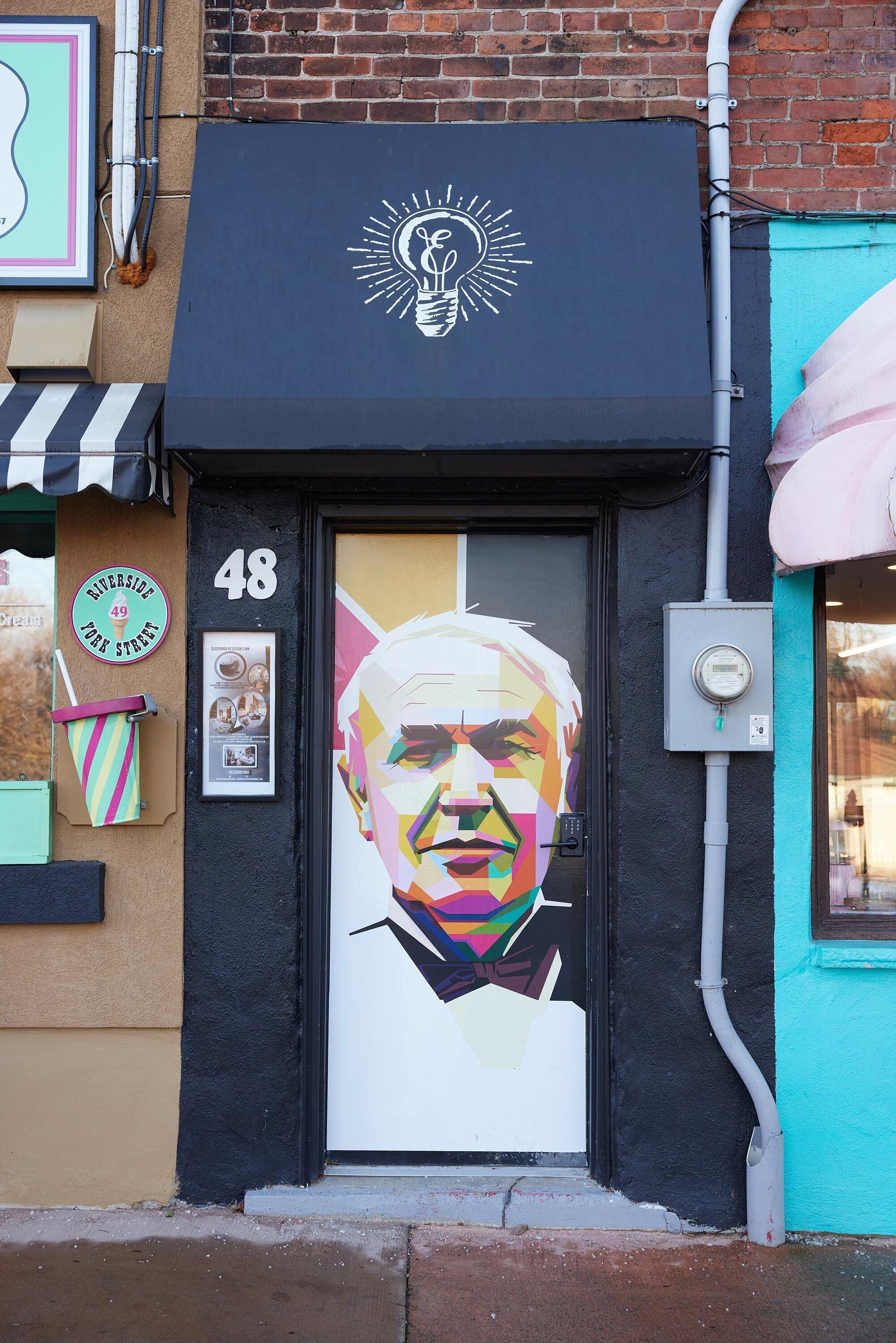 A storefront with a large mural of a man, a number '48' above the door, and a sign that says 'University of York Street'.