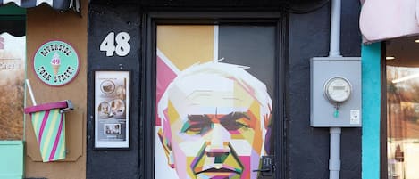 A storefront with a large mural of a man, a number '48' above the door, and a sign that says 'University of York Street'.