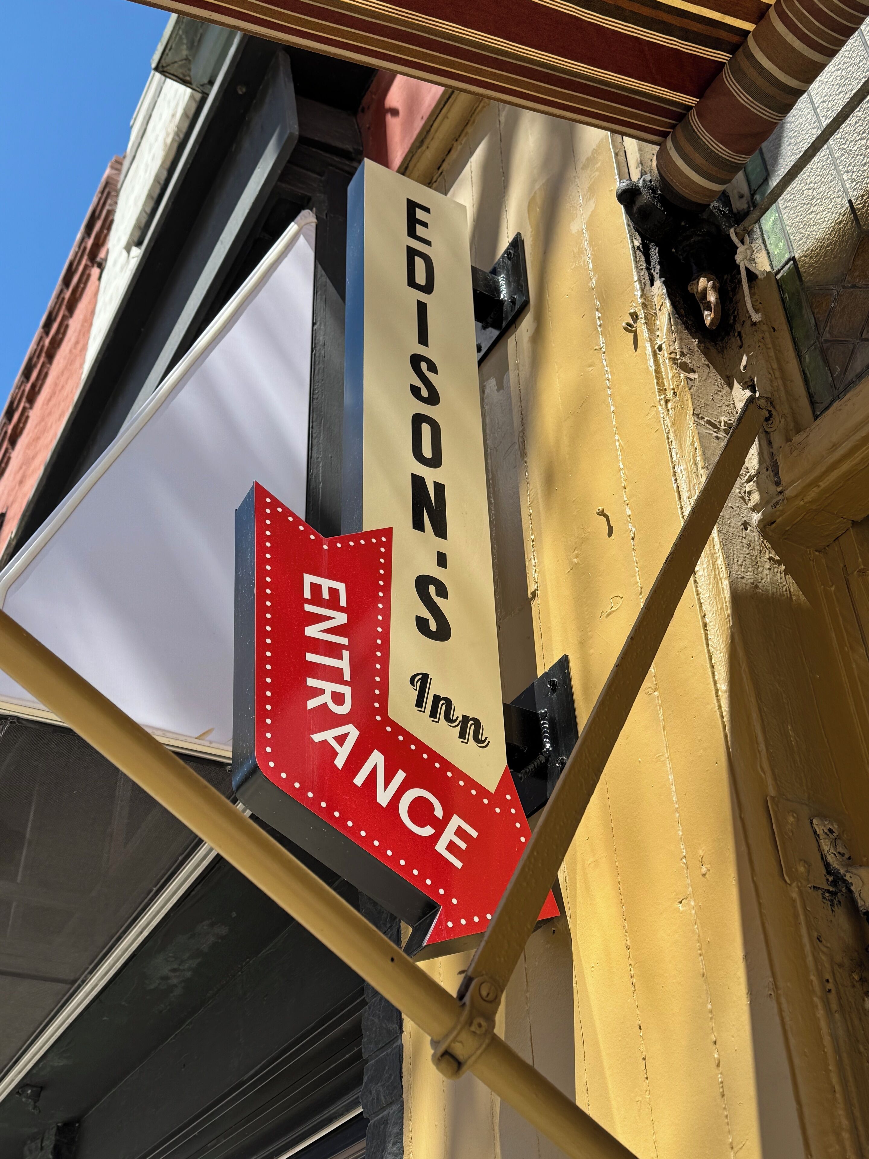 A hotel sign with "EDISON'S 1st Inn" and an "ENTRANCE" sign below it.