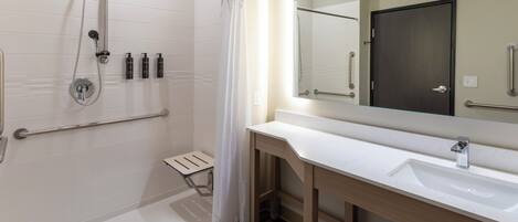 A modern bathroom with a shower, a sink, and a mirror.