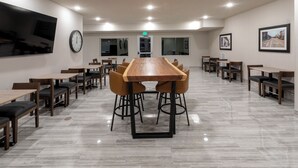 Een vergaderruimte met een lange tafel, stoelen en een klok aan de muur.