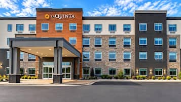 A multi-story hotel with a prominent 'La Quinta' sign, a covered entrance, and a parking lot.