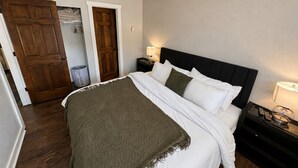 A bedroom with a bed, bedside tables, a lamp, and a door. - The Powder Haven Chalet (Park City)