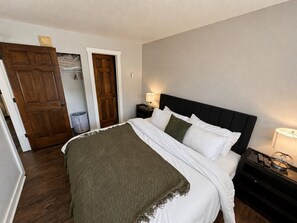 A bedroom with a bed, bedside tables, a lamp, and a door. - The Powder Haven Chalet (Park City)
