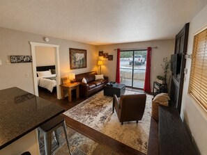 A compact living space with a kitchenette, a sofa set, a coffee table, and a fireplace. - The Powder Haven Chalet (Park City)
