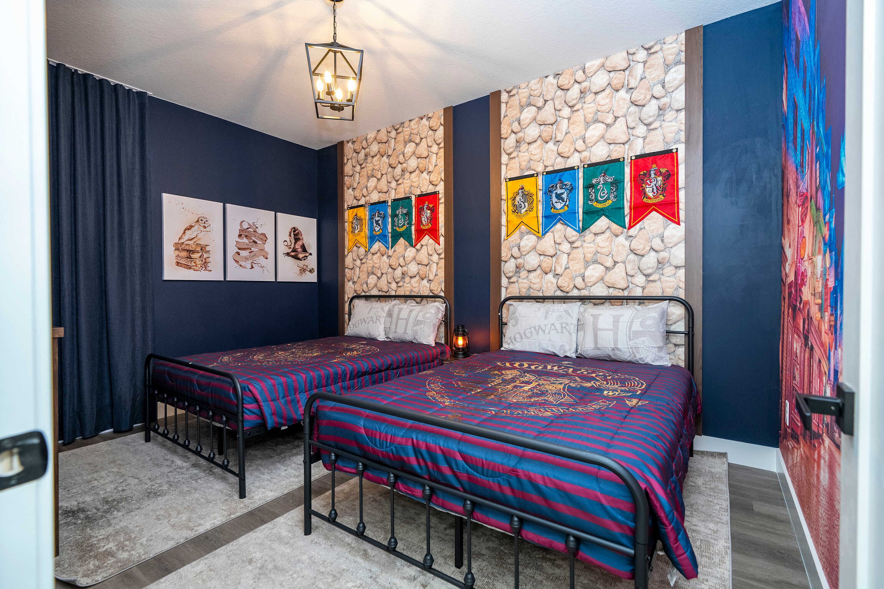 A room with two beds, a stone wall, and a series of flags.