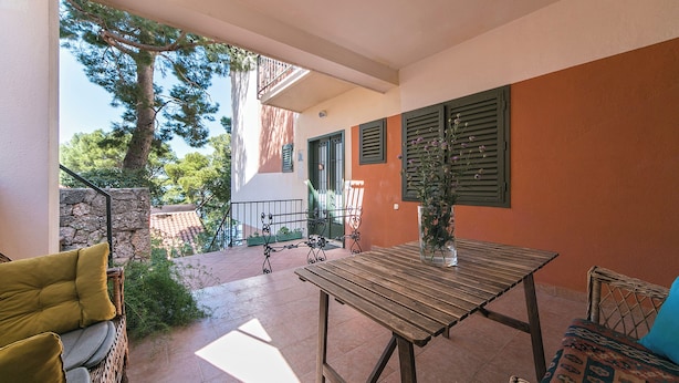 A balcony with wicker furniture, a table, and a potted plant. - Enchanting apartment with WiFi in beautiful Brela with a loggia (Brela)