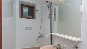 A bathroom with a toilet, sink, mirror, and shower. - Enchanting apartment with WiFi in beautiful Brela with a loggia (Brela)