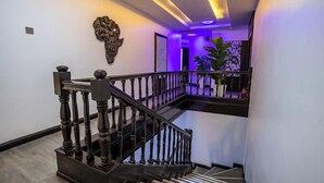 A staircase with dark wooden balusters and a modern light fixture above. - Kashco Apartments (Abuja)