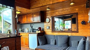 Una cocina acogedora de estilo cabaña con armarios de madera, lavavajillas integrado y un ventanal grande.