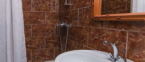 A bathroom with a bathtub, a sink, and a shower.