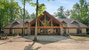 Un chalet doté d’une façade en pierre, de poutres en bois et d’une allée gravillonnée.
