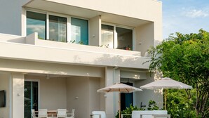 Ein modernes, zweistöckiges Haus mit Pool, Außenbereich und gepflegtem Rasen.