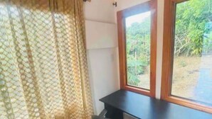 A room with a desk, chair, and a window with a view of greenery. - Lovely cabin with WiFi in charming Circasia (Circasia)