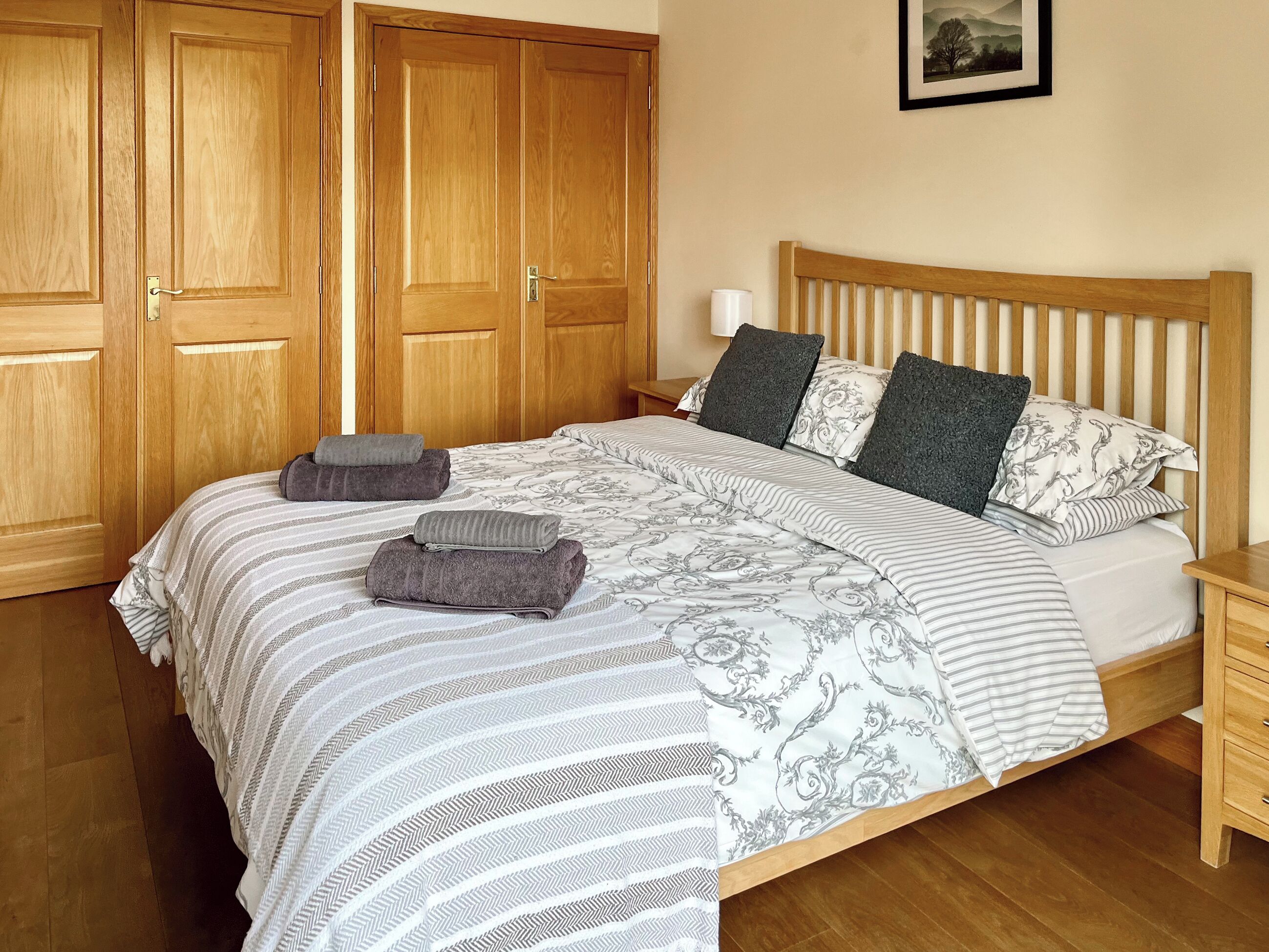 Ein Schlafzimmer mit einem großen Bett, einem Holzschrank und einem Nachttisch.