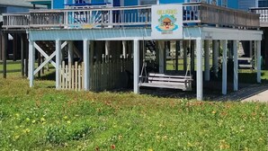 Ein zweistöckiges Gebäude mit blauer Fassade und einer Veranda.