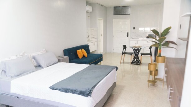 Une chambre d’hôtel comprenant un lit, un canapé, une table à manger avec des chaises et un coin cuisine.