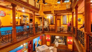 A multi-level hotel lobby with ornate woodwork, a central staircase, and a Star Wars-themed display. - Anastasia Island Retreat (St. Augustine)
